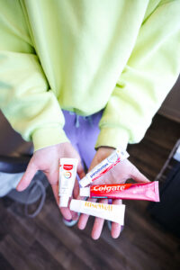 A photo of a woman holding toothpaste. Brushing your teeth is good for your oral hygiene