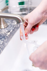 An Invisalign patient practicing good Invisalign care by washing her Invisalign